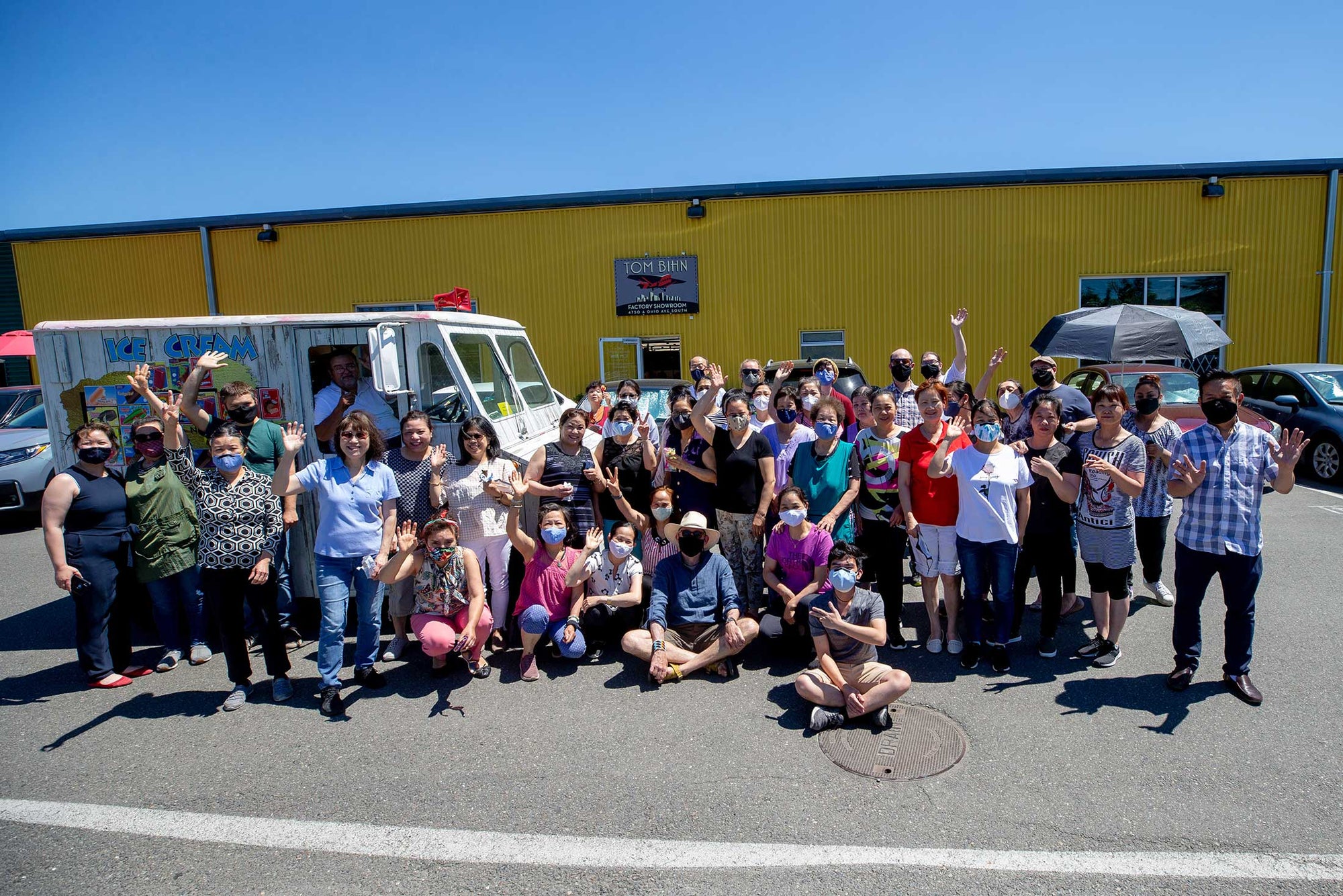 A group photo of TOM BIHN crew outside of their factory, enjoying ice cream in front of an ice cream truck.